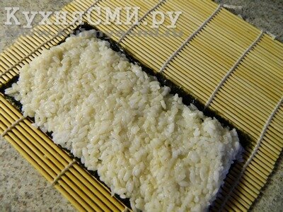 Распределяем слой отваренного риса толщиной 0,5 см