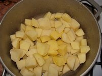 Картофель очистить, нарезать крупными кубиками и всыпать в чугунок