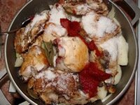 На лук положить слой жареной курицы, добавить томат-пасту, соль, сахар, специи