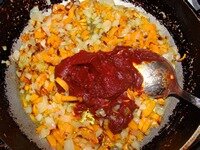Когда лук с морковью слегка прижарятся добавить томатную пасту